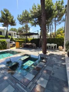 a swimming pool in a yard with a tree at Peonia Villa ValaMar in Draç
