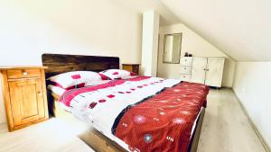 a bedroom with a bed with a red and white blanket at Chata u Studnaře in Křivoklát +13 photos
