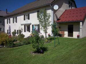 a white house with a red roof and a yard at Gites familiaux à Lajoux à 1180m d'altitude in Lajoux