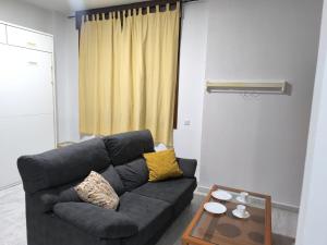 a living room with a black couch and a table at Lux Sevilla Elegance in Seville +1 photo
