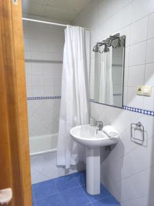 a white bathroom with a sink and a shower at Lux Sevilla Elegance in Seville