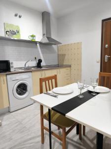 a kitchen with a table and a washing machine at Lux Sevilla Elegance in Seville