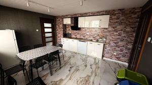 a kitchen with a table and a brick wall at Noclegi lebudbis in Wąchock +13 photos