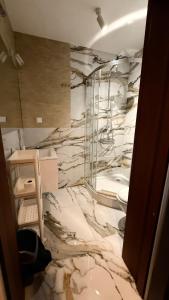 a marble bathroom with a shower and a toilet at Noclegi lebudbis in Wąchock
