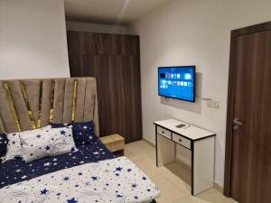 a bedroom with a bed and a desk and a television at Nest Nova in Alagbado +3 photos