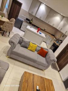 a grey couch with pillows in a living room at Nest Nova in Alagbado