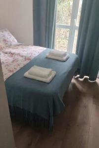 two towels are sitting on a bed with a window at Apartamenty Raszyn in Raszyn