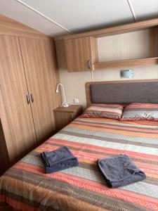 a bed in a small room with two towels on it at Seton Sands in Port Seton