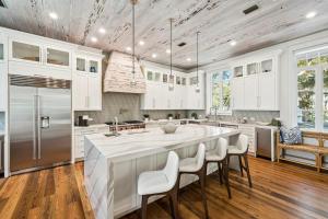 a kitchen with a large island with white cabinets at Serenity Now in Rosemary Beach