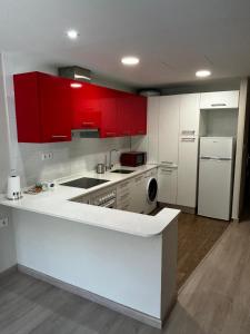 a kitchen with red cabinets and a white refrigerator at Casa Aliseda in Béjar