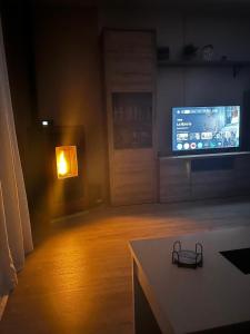 a living room with a tv and a table with a light at Casa Aliseda in Béjar