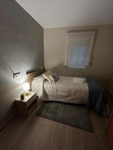 a bedroom with a bed with a window and a rug at Casa Aliseda in Béjar +7 photos