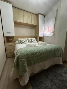 a bedroom with a bed with a green comforter at Casa Aliseda in Béjar