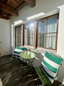 a room with two chairs and a table and windows at Cosy studio apartment in Splügen in Splügen +47 photos