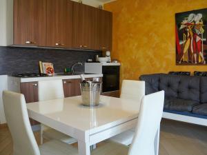 a kitchen and dining room with a white table and chairs at New Home Lazise in Lazise +6 photos