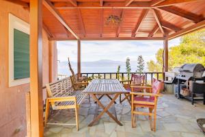 a patio with a table and chairs and a grill at Fragola in Pefkali