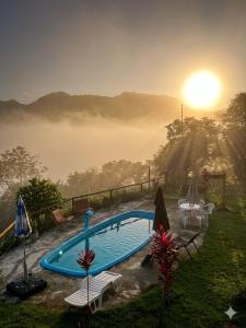 a swimming pool with a sunset in the background at CHÁCARA DOMINGOS MARTINS - SANTO GRAAL - Montanhas, Corredeiras, Piscina, Natureza e Paz in Domingos Martins