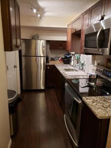 a kitchen with a stainless steel refrigerator and a sink at Parson Creek Cozy suite in Fort McMurray