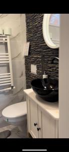 a bathroom with a black sink and a toilet at La Tarani in Vatra Dornei +61 photos