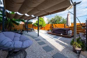 a patio with a blue chair under a canopy at Ante room's in Trogir +18 photos