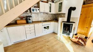 a kitchen with white cabinets and a wood stove at Chata u Studnaře in Křivoklát