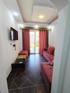 a living room with a red couch and a tv at Chalets in Porto Matrouh Families Only in Marsa Matruh