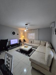 a living room with a couch and a tv at Duomo Apartament in Shkodër