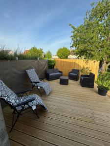 a patio with two chairs and a couple of seats at Le Nid d'escale in Tillé