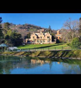 a large house with a river in front of it at Oasi di Comago in Sant'Olcese