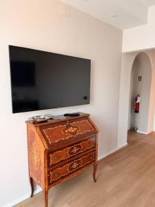 a wooden dresser with a flat screen tv on a wall at Oasi di Comago in Sant'Olcese +9 photos