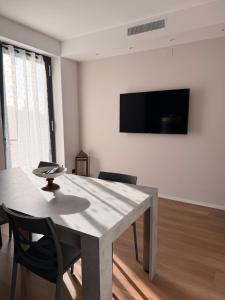 a dining room with a table and chairs and a television at Oasi di Comago in Sant'Olcese