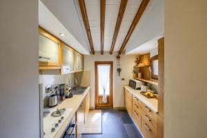 a large kitchen with wooden cabinets and a ceiling at Mhateria Relais - Relax in Villa con Piscina in Toscana in Rignano sullʼArno +108 photos