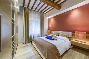 a bedroom with a large bed and a red wall at Mhateria Relais - Relax in Villa con Piscina in Toscana in Rignano sullʼArno