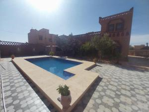 a swimming pool in front of a building at Moon Dunes camp in Adrouine