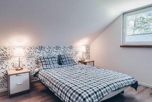 a bedroom with a bed with a plaid blanket and two lamps at JEZIORAKI Uroczy domek i sauna 400m od jeziora Nowa Jedlanka in Jedlanka Nowa