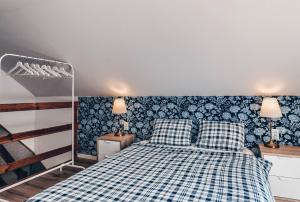 a bedroom with a blue and white bed with two pillows at JEZIORAKI Uroczy domek i sauna 400m od jeziora Nowa Jedlanka in Jedlanka Nowa
