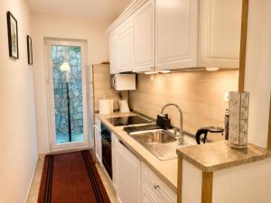 a kitchen with white cabinets and a sink at Bonita Apartments in Mostar