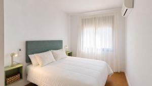 a bedroom with a white bed and a window at La Sènia in Miravet