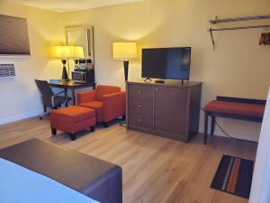 a living room with a flat screen tv and furniture at Carolyn Beach Inn in Thessalon