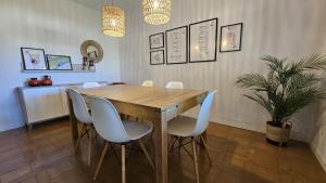 a dining room with a wooden table and white chairs at La Sènia in Miravet