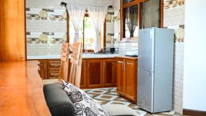 a kitchen with a refrigerator and a table in it at La Vue De Mer in La Digue