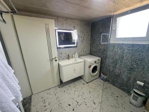 a bathroom with a washing machine and a sink at Prive Home in Maliq +8 photos