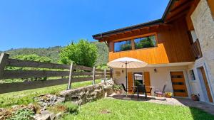 a house with a table and an umbrella at Ledro Nest in Ledro