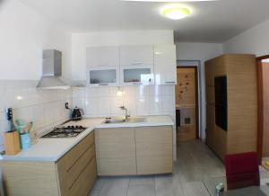 a kitchen with white cabinets and a sink and a stove at Vila Vinka Tito in Igrane