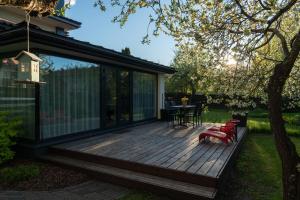 a wooden deck with a table and chairs on it at Villa Aia Apartment in Pärnu
