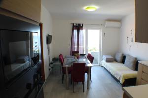 a living room with a dining room table and a couch at Vila Vinka Tito in Igrane