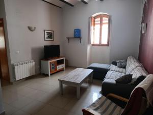a living room with a couch and a tv at Complejo Rural La Belluga in Segorbe