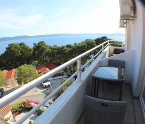 a balcony with chairs and a view of the water at Vila Vinka Tito in Igrane