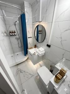 a white bathroom with a toilet and a mirror at Ismail 94-1 Apartments in Chişinău +39 photos