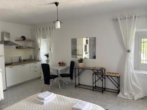 a kitchen with a table and two chairs and a table at Kambi rooms in Himare